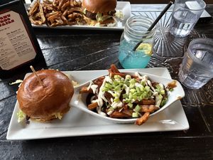 Classic burger with poutine and blue mocktail .  at The Buckingham in Edmonton