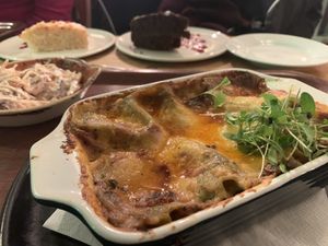 Mushroom Lasagna with cakes and coleslaw in the background at Henderson's Vegan in Edinburgh