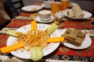 Hummus with bread, soy vanilla latte (the one and only in town!), famous wrap on the background. at Kiwi Vegan Cafe in Tbilisi