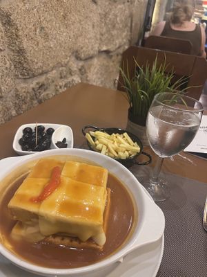 The francesinhas with fries, plus seasoned olive starter  at Francesinhas Al Forno da Baixa in Porto