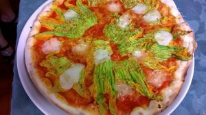 Pizza with tomato, vegetable mozzarella and zucchini flowers at Gorilla Bianco in Querceta