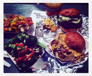 clockwise from top left; mambo potatoes > vegan superiority burger > yuba philly sandwich > burnt broccoli salad at Superiority Burger in New York City