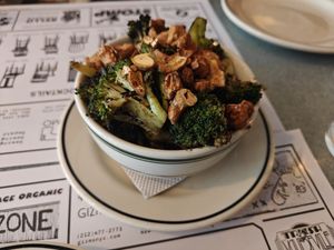 Broccoli and nuts side dish, has a dip along the sides of the bowl at Superiority Burger in New York City