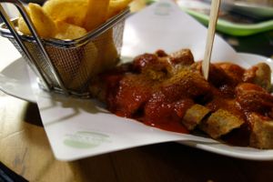 Vegan tofu sausage in curry sauce with chips 'Currywurst mit Pommes' at Hans und John  in Schwerin