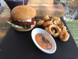 Special burger (quinoa based) with coleslaw filling and onion rings  at Cavoli Nostri in Naples