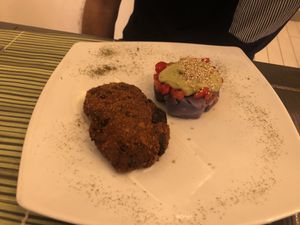 Aubergine balls, with a side of purple potatoes, avocado cream and tomatoes  at Cavoli Nostri in Naples