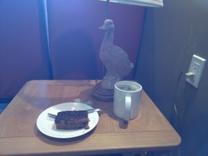Vegan carrot cake with coffee and duckish table lamp. at Heaven on Earth Cafe in Vancouver