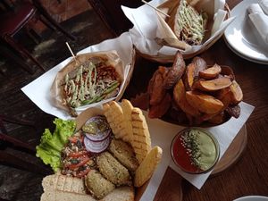 Hummus, potato wedges with sauces and one burger (cut in half)  at Public Bar & Vegan Kitchen in Bled