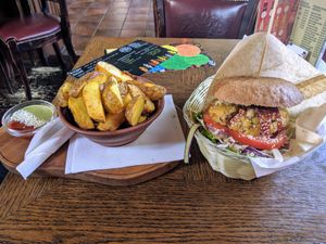 Specialty burger with potato wedges. Very tasty and filling! at Public Bar & Vegan Kitchen in Bled
