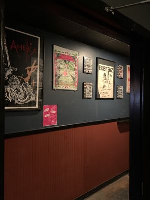 View of the bathroom hall. The decor is mostly black walls with tons of very punk posters.  at Black Water Bar in Portland