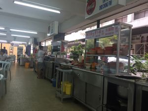 the helpful waitress plating up our food at Blue Boy Vegetarian Food Centre in Kuala Lumpur