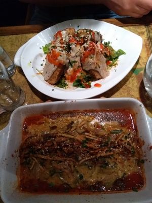 Above: vegan kebap with tahini sauce. Under: seitan with smoked tofu on top in tomato sauce at Karuzo in Sarajevo