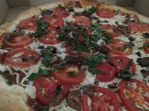 Pizza with tomatoes, mushroom and cilantro at Red Brick Pizza in Las Cruces
