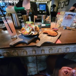 NACHOS: housemade ‘cheese’ sauce, black beans, cumin crema, pickled jalapeno, guacamole and PHILLY STEAK EMPANADAS ‘Cheese’, corn, pico de gallo, spicy ketchup at Bar Bombon in Philadelphia