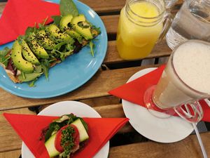 Avocado toast, open sandwich, drinks: pineapple juice & chai latte at bistRAW & Tea in Prague