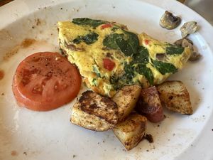 Veggie omelette with Just egg and vegan cheese, homestyle potatoes and tomato slices  at Global Cafe  in Lawrence