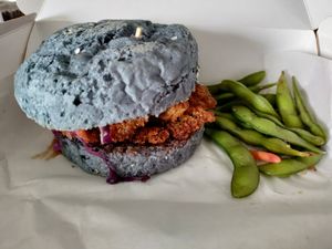 Butterfly pea bun filled with coleslaw and battered mushroom at SoyGreen in San Salvador