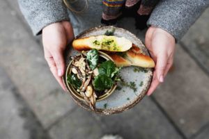White beans with spinach, oyster mushrooms and thyme in white wine sauce, served with baguette at Cafe Kulturalna in Warsaw