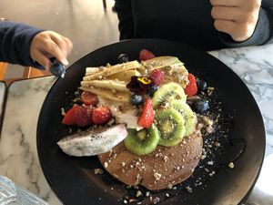 buckwheat pancakes - topped with coconut yoghurt, fresh seasonal fruit, caramelised pecans and maple syrup
 at Redemption - Chepstow in West London