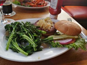 Impossible burger, they let you substitute fries for garlic sweet potato fries or sauteed vegetables with garlic as shown here at Half Moon Bay Brewing Company in Half Moon Bay