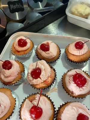 Soft and fluffy vegan gluten-free Cherry cupcakes topped with vegan cherry frosting and finished with a cherry on top.  at Eden's Vegan Juice Bar Cafe in Palm Coast