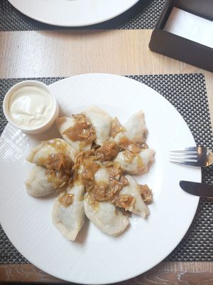 Dumplings with a filling of spinach, dried tomatoes and tofu, onion topping at Pierogarnia Mandu Oliwa in Gdansk