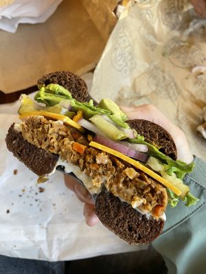 Pumpernickel rye with avocado, veggie patty, cheddar, avocado, red onion, cream cheese, mustard, pickles, lecture  at Blazing Bagels in Bellevue