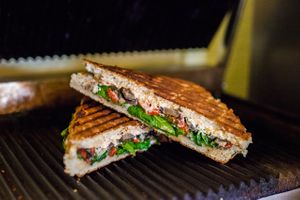 Fiery Fun-Gi-Focaccia, spicy goat cheese, black bean hummus, candied jalapeños, roasted red peppers, portobellos, greens. at Cultivate Cafe in Destin