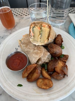 Breakfast wrap made with chickpea frittata, spicy cashew aioli, cashew mozzarella and pickled veggies...DELICIOUSNESS! What an amazing breakfast/brunch spot in Little Italy!  at Cafe Gratitude in San Diego