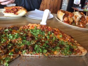vegan sausage & broccoli pizza. vegan chicken parm and vegan buffalo sub in the background  at Little Anthony's in Albany
