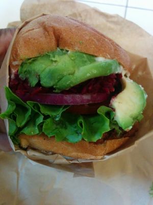 Avocado beetroot burger; crisp GMO free plant protein patty topped with avocado, shredded beets, red leaf lettuce, sliced red onion, creamy vegan aioli, whole wheat bun at VeganBurg in San Francisco