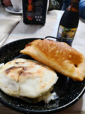 Empanada and arepa for breakfast, served with Maltin. Typical Venezuelan breakfast at Casa Manuel in Sarria