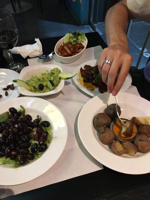 Olives, guacamole, vegan sausages, sun dried tomatoes, canary island potatoes  at The Mantraa in Barcelona