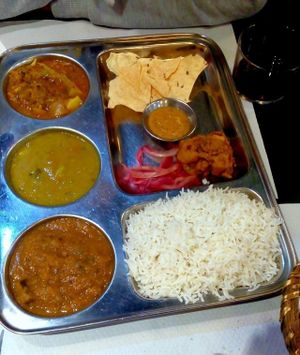 Second course of the menu with 2 courses, dessert, bread and wine for 8, 50€  - mixed Thai plate with basmati rice, broccoli curry, zucchini tomato spicy curry and red lentil curry; fried cauliflower wing with sour sauce and salty cumin crekers  at The Mantraa in Barcelona