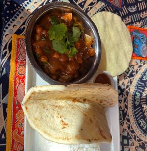 Kadala curry of chickpeas and spinach with side rice, poppadom and small naan  at Cafe Shanti in Lincoln