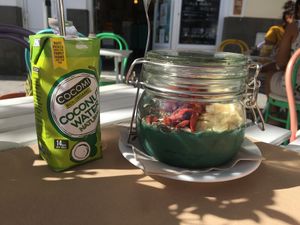 Package of tasty organic coconut water and the smoothie bowl served in a glass jar.  at H2O Juice Bar & Vegan Cafe in Fuerteventura