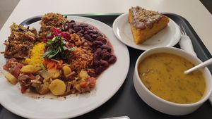 12 EU 'big' meal, including a feijão, tofu stew, pizza slices, vegetable soup and carrot cake. at Escolha Natura in Lisbon