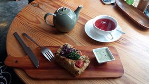 Tea and fugazza with purple onions, parsley and tomatoes, with a side of vegan tartar sauce at La Verde in Lima