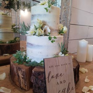 Semi-naked vegan wedding cake in white theme with fresh flowers at The Kind Cake Co in Hebden Bridge