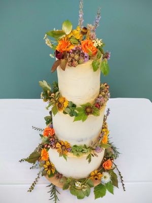 3-tiered vegan wedding cake with fresh seasonal edible flowers and foliage at The Kind Cake Co in Hebden Bridge