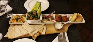 Mezze platter (left to right): hummus, tabbouli, babaganoush, falafel, spinach fritter. There's also complimentary pitta breads and a white sauce with a flavour similar to tahini at Cedar Lebanese Restaurant in Londonderry