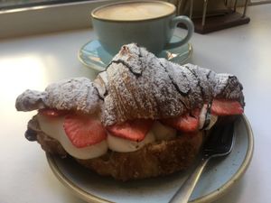 Filled croissant with vegan whip cream, strawberries, chocolate and an oat latte  at Kaf in Copenhagen