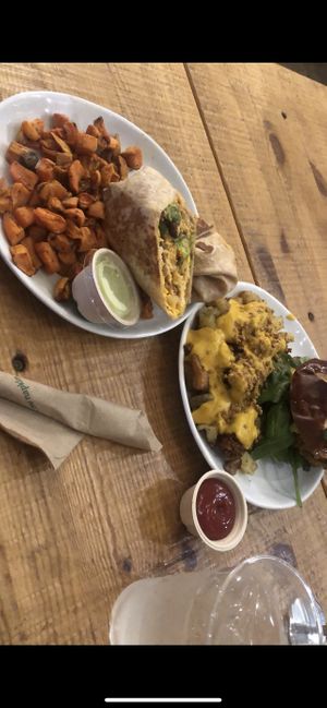 Breakfast Burrito (just egg, picadillo meat, Cheddar cheese, Lettuce) w sweet potato fires & a Superfood burger (Guacamole, Pickles, Cheddar cheese, Kale, Cilantro Aioli) w loaded  at Love Life Cafe in Miami