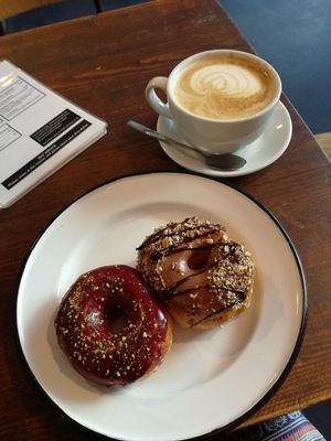 blueberry pistacchio and nougat donuts with a cafe latte at Brammibal's Donuts - Maybachufer in Berlin