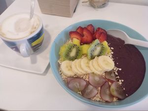 Açai bowl with seasonal fruit + oatmeal and a latté with soy milk at Milk Away in Sevilla