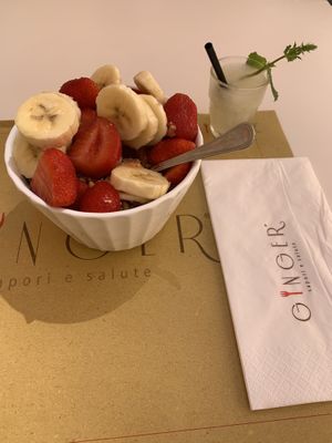 Papaya smoothie bowl with cereal and fresh fruit, on the side an aloe Vera shot  at Ginger in Rome