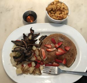 Vegan pancakes with fresh strawberries & warm maple syrup, potatoes with peppers & onions, mushroom sausages, & side order is Mac’n cheese!  at Gnome Cafe in Charleston