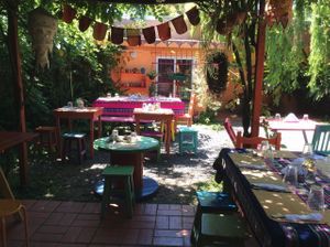 Cozy outdoor seating under the weeping trees at La Cocina de Daksha in Tigre
