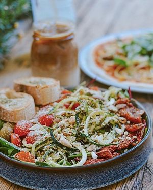 Elli Spirelli Bowl mit Zucchini Spirelli mit Mandel Rucola Pesto, halbgetrockneten Tomaten, Kirschtomaten, Cashew Parmesan, grünen Oliven, gerösteten Kürbiskernen und Wildsalat at Froindlichst - Winterhude in Hamburg