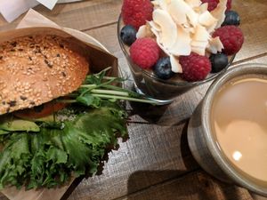 Avocado on a sesame seeded bun with cashew cream cheese and some greenery. Then overnight oats wirh blueberries and raspberries with raw peanut butter. A filter coffee with oatly b at Mahalo - Hornsgatan in Stockholm